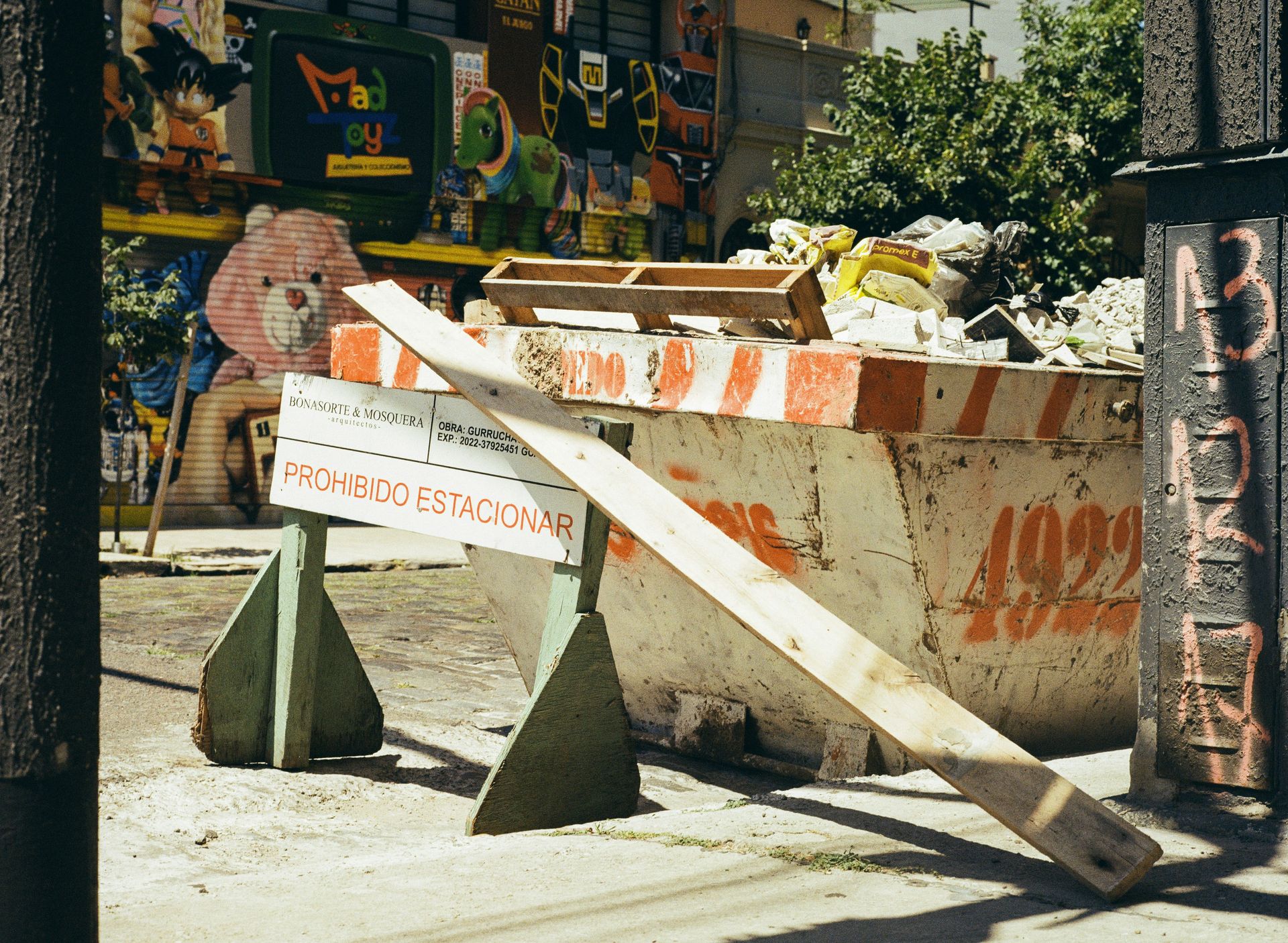 Construction dumpster with a wooden barrier in front